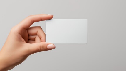 Obraz premium Woman's hand holding an empty silver credit card mockup, close-up high-resolution shot, isolated on clean white or grey background, minimalistic and detailed stock photo.