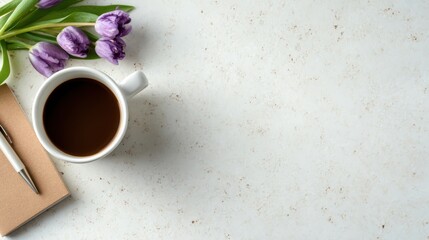 An aesthetic composition featuring a coffee cup, flowers, and a notebook creates a lovely, peaceful workspace vibe perfect for inspiration and productivity.