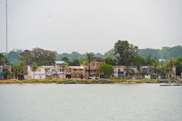 Ziguinchor, Senegal. Residential houses and lush vegetation line the banks of the Casamance River...
