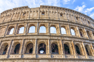 Fototapeta premium Rome, Italy. Colosseum (Coliseum). Ancient Roman Colosseum stands majestically under a blue sky, showcasing its impressive architecture and historical significance in Rome, Italy