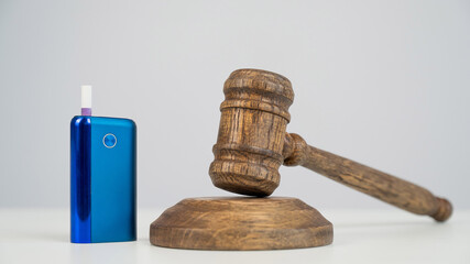 Judge's gavel and electronic cigarette. Smoking ban. Tobacco heating systems. 