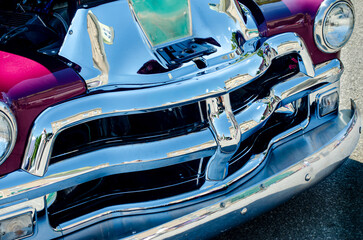 Close-up of a heavy chrome grille on a purple classic car