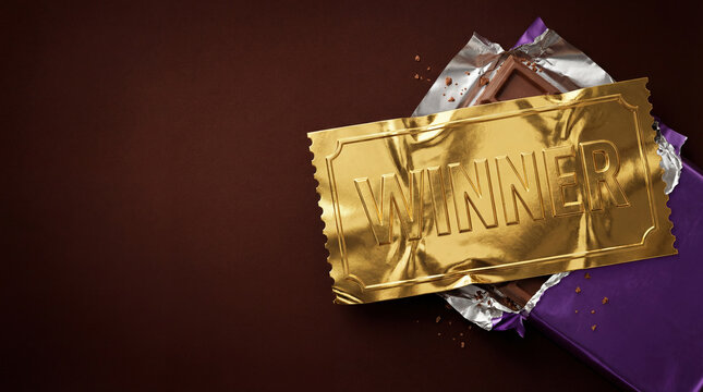 Chocolate bar wrapper opened to reveal golden winner ticket