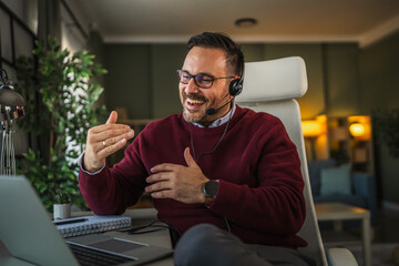 Man in headset having online video call from home office