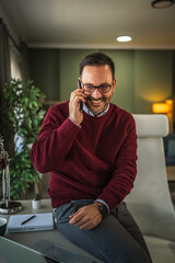 Man laughing while talking on phone working from home