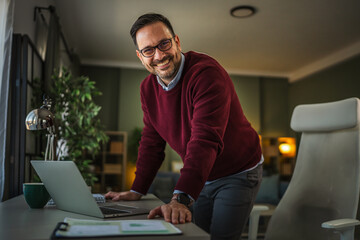 Man working on laptop at standing desk at home