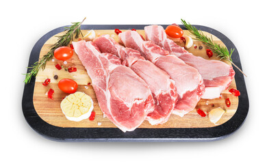 Fresh raw pork slices on wooden board with rosemary, garlic and tomatoes isolated on white background. High quality photo