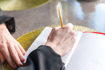 Close-up of a hands holding a pen and a notebook.