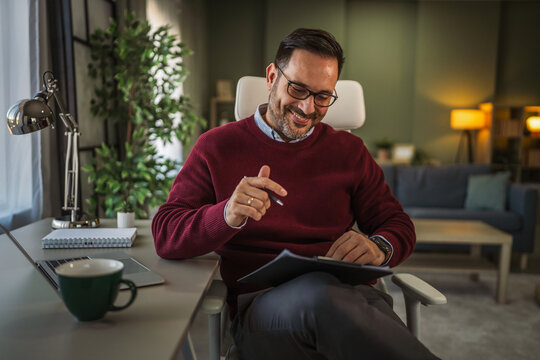 Man working remote from home office reviewing documents