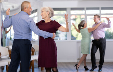 Obraz premium Elderly man and elderly woman dance ballroom dance waltz in studio