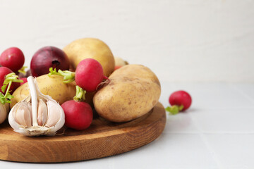 Different raw vegetables on white tiled table, closeup. Space for text