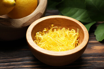 Lemon zest, fresh fruits and leaves on wooden table, closeup