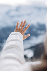 Young woman holding out her hand with an engagement ring against a mountain landscape background