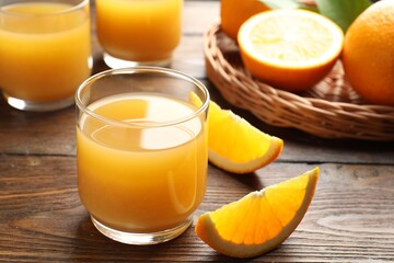Fresh orange juice and fruits on wooden table, closeup