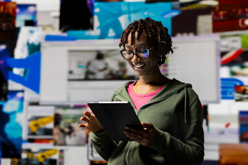 Smiling woman engaging with multimedia dashboards using tablet, showcasing power of technology and digital content. Joyous person having fun interacting with device apps and internet websites