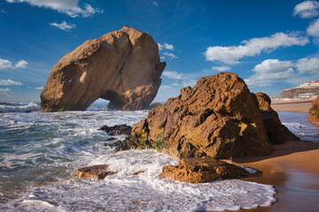 Sunset at Praia da Santa Cruz by Penedo do Guincho rock arch