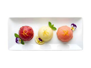 A Delicious Trio of Colorful Sorbet Scoops Topped with Mint and Edible Flowers on a White Plate