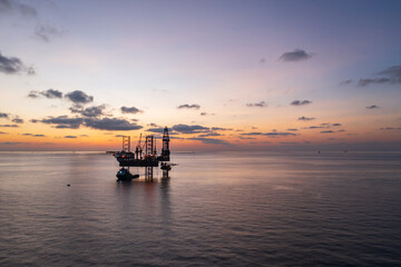 Aerial view of offshore jack up rig and offshore platform during sunset for oil and gas exploration and production.