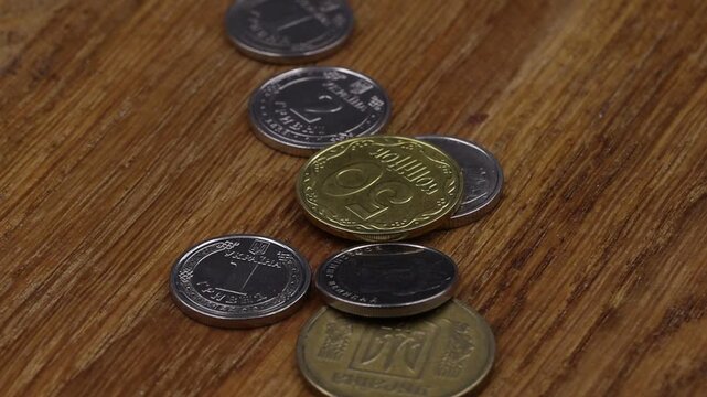 Close up of Ukrainian coins rotating on a wooden table. Perfect for finance, economy, banking, or historical content showcasing Ukrainian currency.