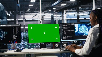 Female programmer talking with manager in data center, reviews AI diagnostics on green screen PC. IT expert and supervisor optimizes artificial intelligence systems using mockup computer, camera A