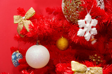 Christmas tree decoration with colorful ornaments and red background in a festive setting