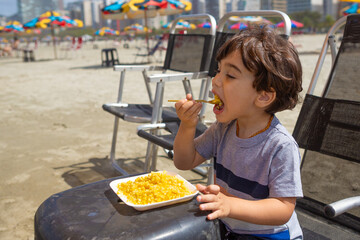4 year old boy eating boiled corn