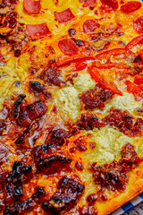 Close-up of a slices of Diverse Pizza Varieties on Checkered Paper