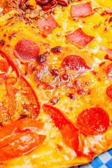 Close-up of a slice of pizza with artisanal pepperoni, mixed cheeses, and Neapolitan sauce