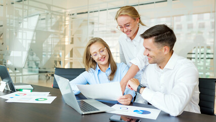 Fototapeta premium Team members review documents in office setting