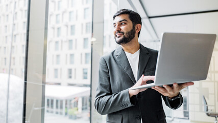 Fototapeta premium Businessman working with laptop in office setting