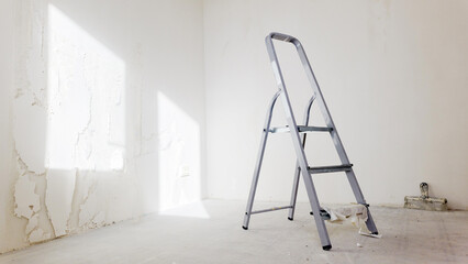 Ladder stands in empty room awaiting work