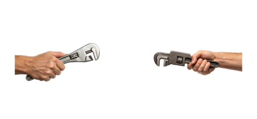 Two male hands holding different metal wrenches face each other in a conceptual image of competition, repair, and manual labor with dramatic studio lighting