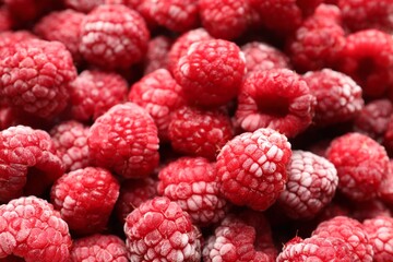 Frozen ripe raspberries as background, closeup view