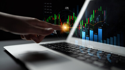 A hand interacts with a futuristic laptop display, showcasing real-time data analytics, stock trends, and investment growth visualizations in a modern workspace. Scalp