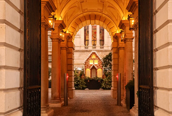 London Christmas courtyard with festive gingerbread house and illuminated seasonal decorations at...