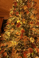 Christmas tree decorated with golden ornaments and sparkling lights celebrating festive holiday...
