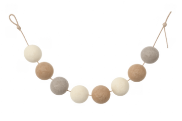 Felt ball garland decorating nursery wall with neutral colors