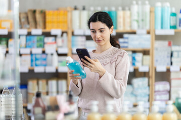 European woman scans the barcode of a mouthwash in a pharmacy. Purchase and payment for goods in a pharmacy using a QR code