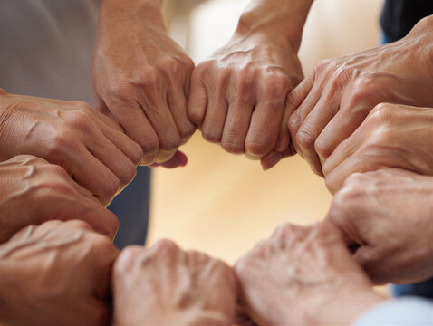 Diverse group of people joining hands in a circle for unity and support