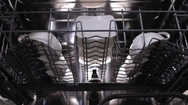 Dishwasher loading process showing plates arranged in racks, highlighting the organization of dishes for optimal cleaning efficiency and space utilization in the appliance
