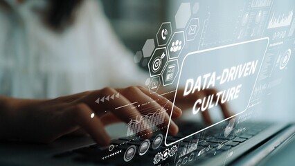 Fototapeta premium Hands Typing on Laptop with Data-Driven Culture Concept Graphic Overlay for Business and Technology Themes. Asymptotic smart data analytic.