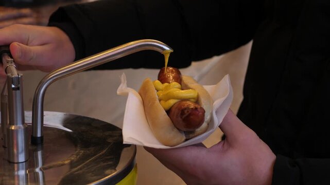 Close-up of hot dog with mustard and ketchup, Concept of comfort, warmth, hygge, winter relaxation, simple pleasures, and seasonal food and drink.