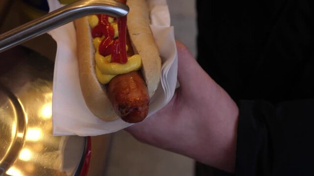 Close-up of hot dog with mustard and ketchup, Concept of comfort, warmth, hygge, winter relaxation, simple pleasures, and seasonal food and drink.