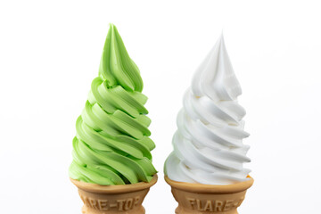 白背景に並ぶ抹茶ソフトクリームとバニラソフトクリームのコーン