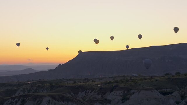 Hot air balloons flying over Cappadocia Turkey at sunrise