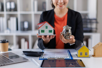 Female Real Estate Broker presenting and advised to model home and building project detail in the office, sign purchase sales contract, agreements concerned mortgage loan offer and insurance.

