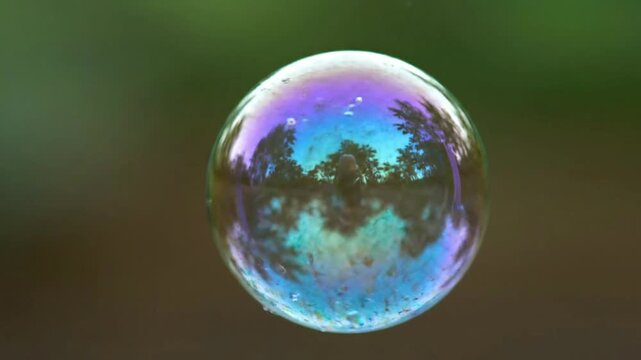 Reflections on a bubble, ethereal floating iridescent sphere