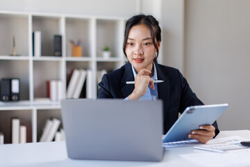 Business asian woman working at office with tablet and document, doing planning analyzing the...