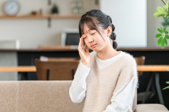 Elementary and middle school girls holding their temples due to headaches