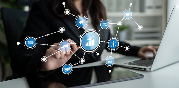 A businesswoman interacts with a digital data interface, showcasing statistical growth and analysis while working on a laptop in a professional environment. Crux - Powered by Adobe